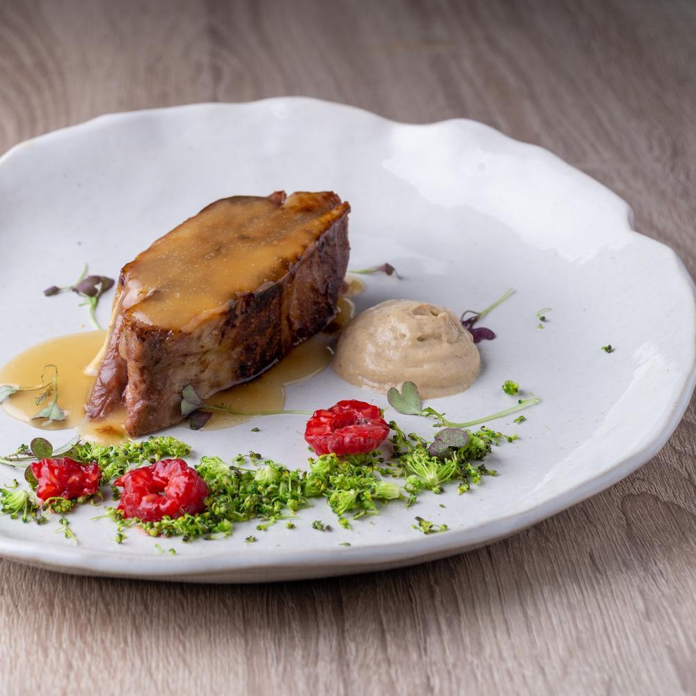 Terrina de cordero con espuma de sus interiores, brócoli y frambuesas. © Mentica Gastronómico