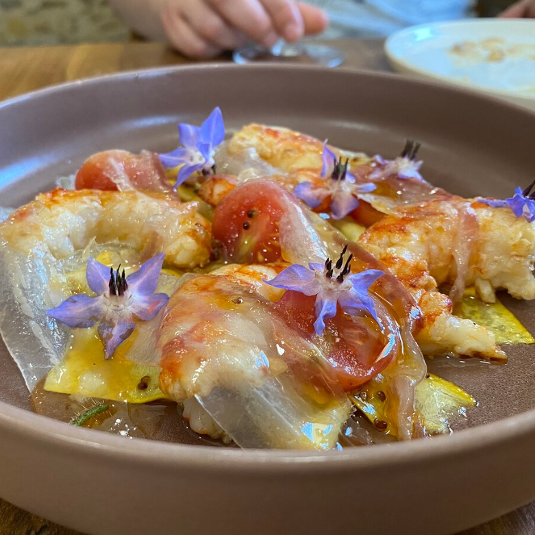 Langostino con velos de panceta de cerdo ibérico y flores de borraja. © Existe